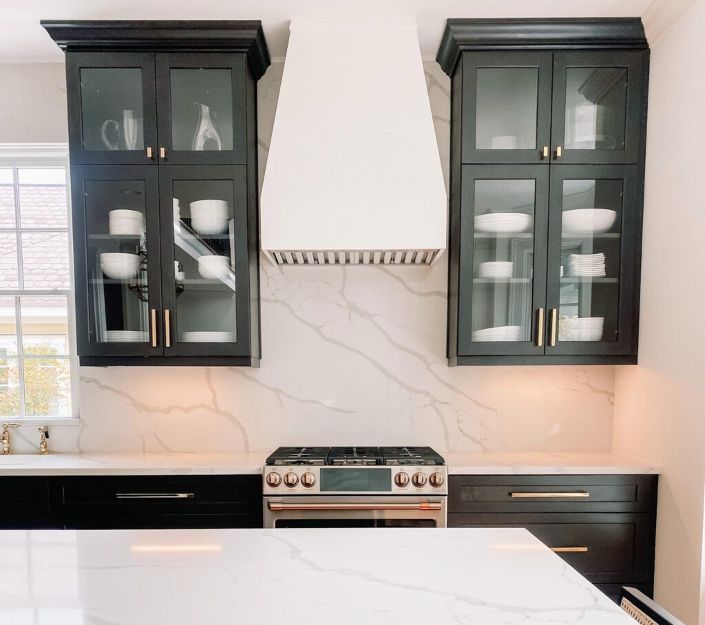 White hood black cabinets with quartz backsplash