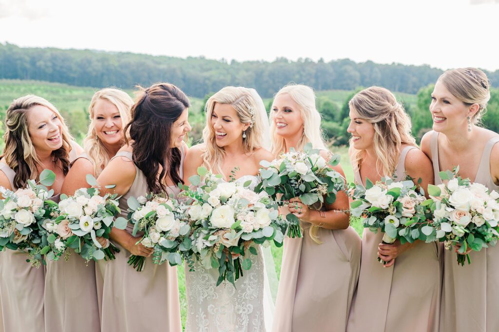 Bridesmaids in champagne dresses with green and white flowers