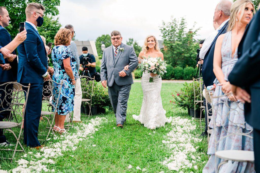 Bride walking down the aisle in vineyard