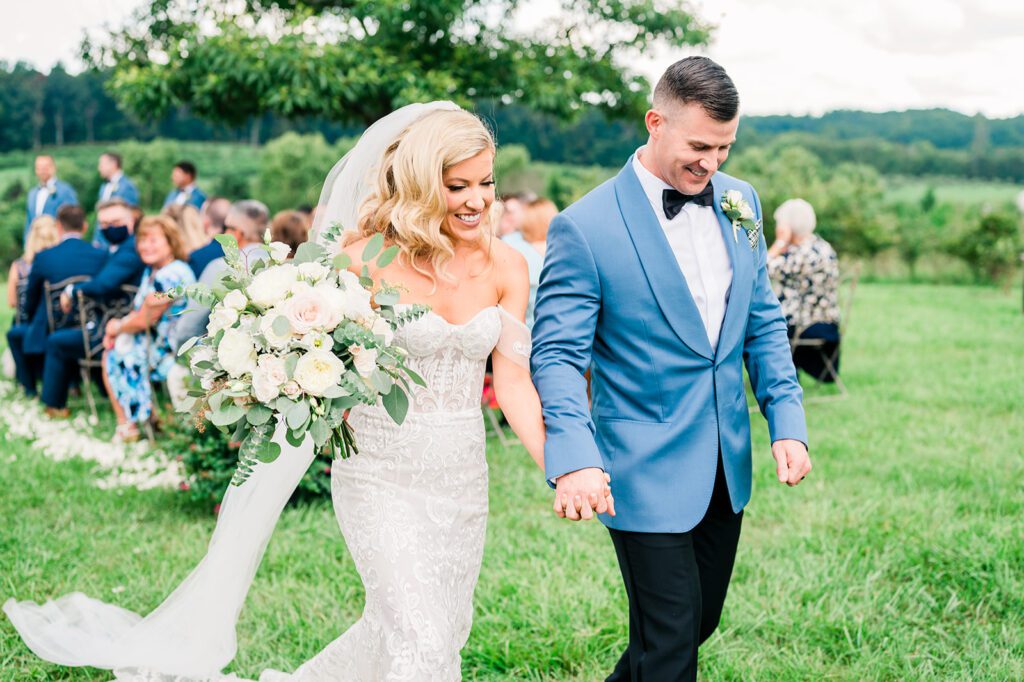 Bride and groom walking down aisle in vineyard wedding