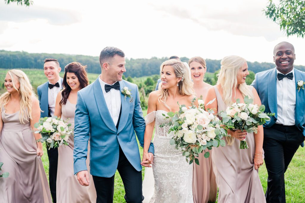 Wedding party outside in champagne dresses and blue tuxedos