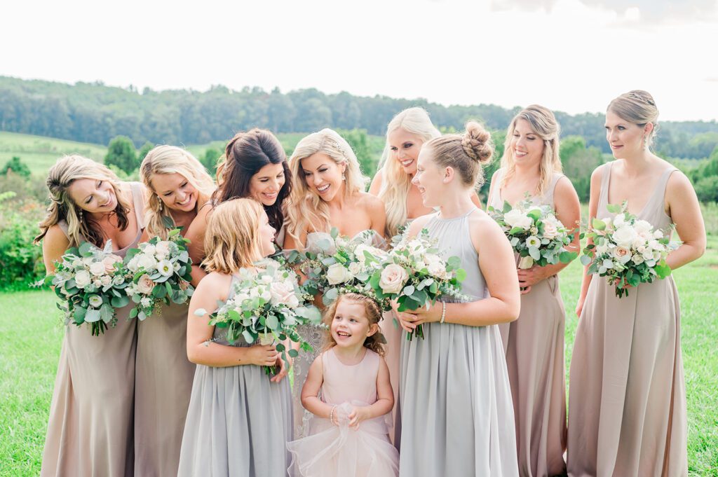 Bridesmaids and flower girl in champagne dresses with green and white flowers