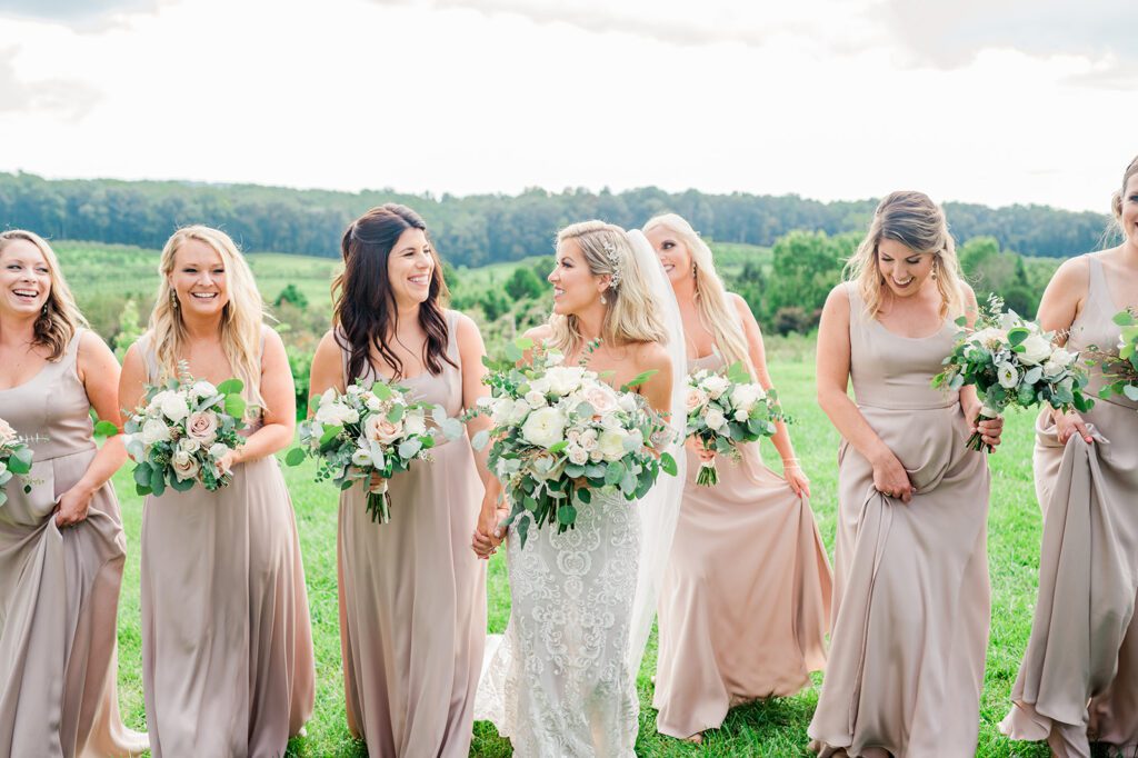 Bride and Bridesmaids in champagne dresses and greenery in vineyard