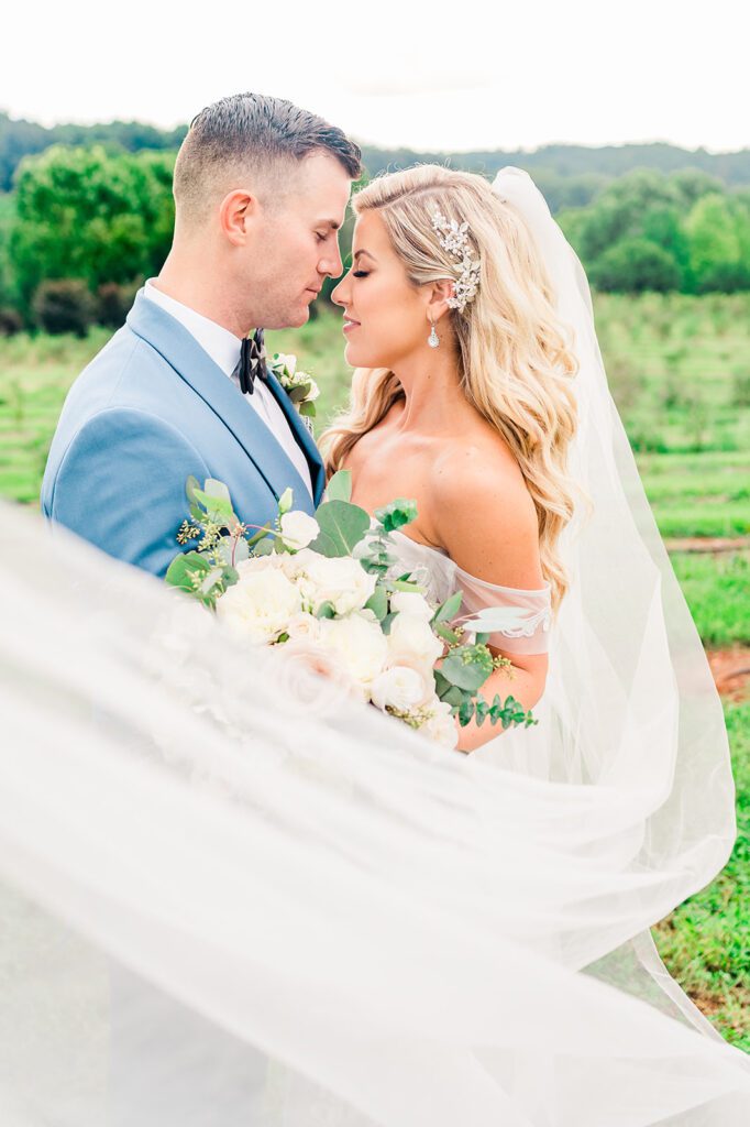 Bride and Groom in vineyard with veil blowing in the wind