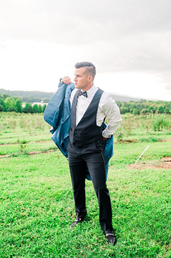 Groom putting on baby blue tuxedo jacket