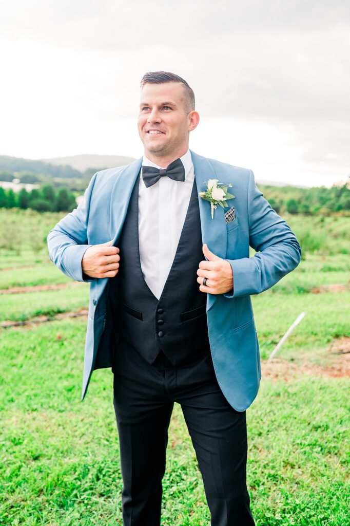 Groom adjusting baby blue tuxedo jacket