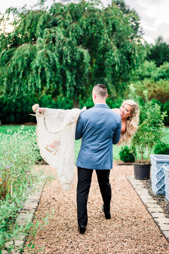 Groom sweeping bride off her feet laughing