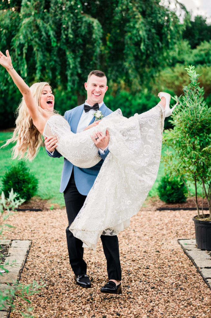 Groom sweeping bride off her feet laughing