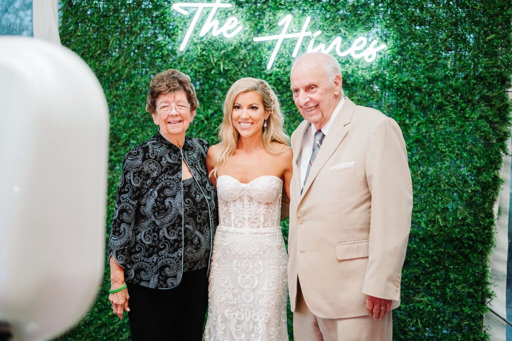 Bride with grandparents in front of photo booth