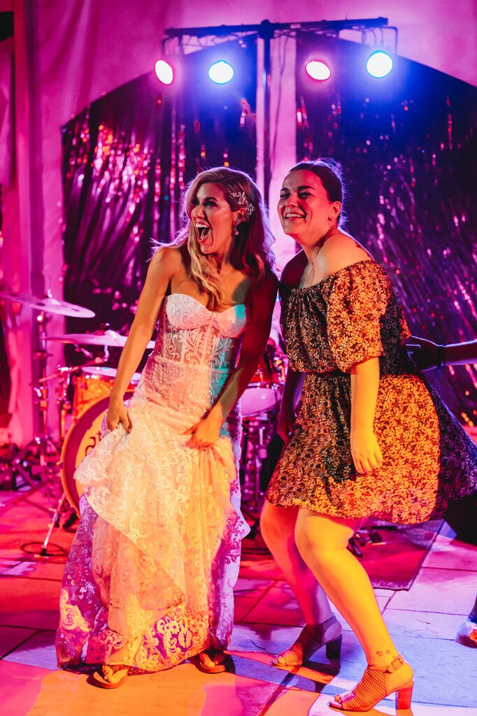 Bride and friend dancing at reception to live band