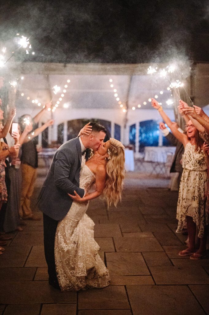 Bride and groom kissing in sparkler send off