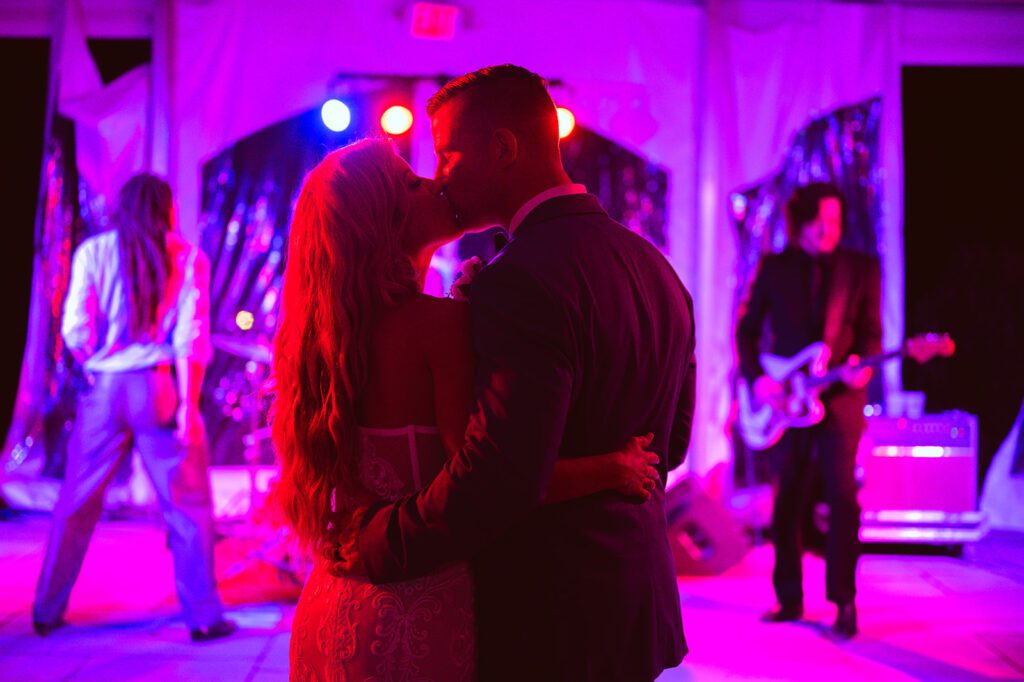 Bride and Groom kissing in front of live band