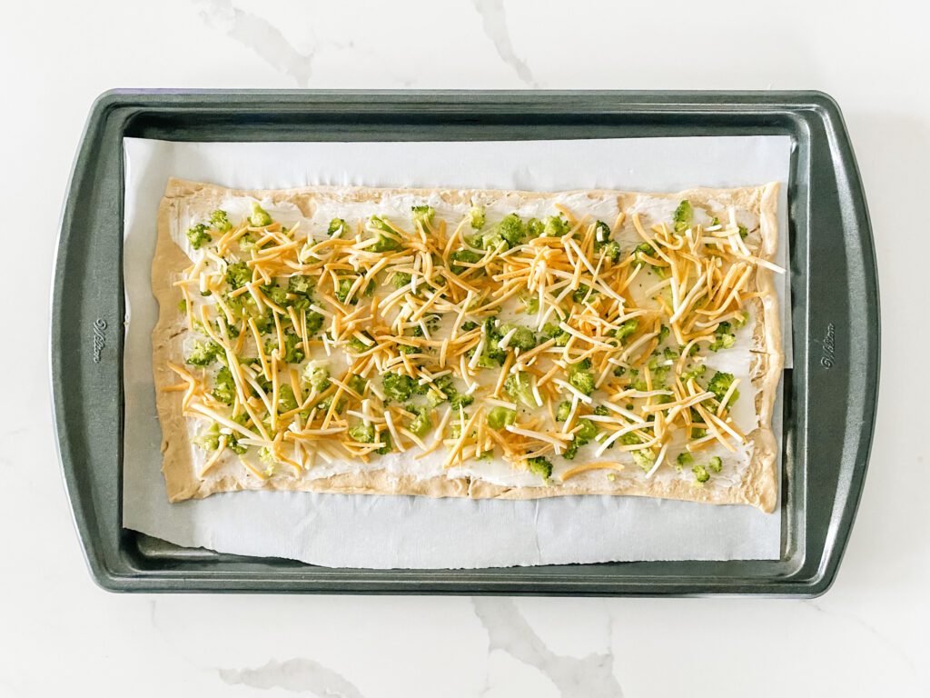 Crescent roll with cream cheese and broccoli and shredded cheese