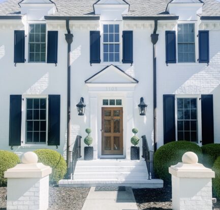 White house black shutters with topiary planters